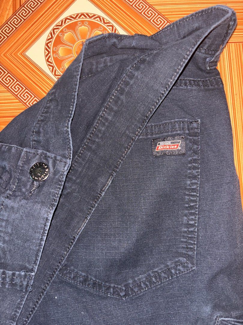 Genuine Dickies Black Cargo Work Pants (Category: Trousers) located in Polomolok. Submitted by rrthrift (Listing ID 1470503230, Image 3). Description: - Brand: Genuine Dickies - Color: Dark Navy Blue Size 36 length 41 - Material: Heavy-duty cotton with ripstop texture - Pockets: Multiple utility pockets on sides and back - Closure: Standard button and zipper fly - Style: Classic utility workwear.