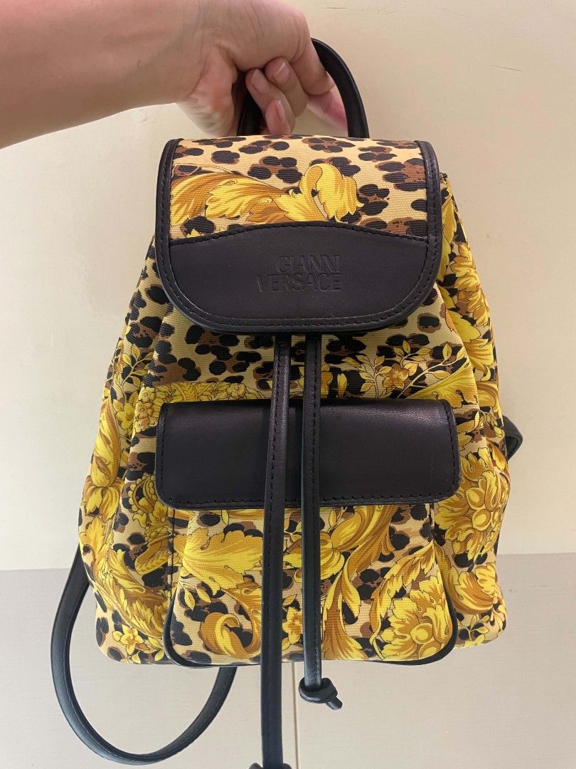 Gianni Versace (With Issue)Baroque Leopard Print Backpack (Category: Backpacks) located in Plaridel. Submitted by collectors_blocc (Listing ID 1470459362, Image 1). Description: - Brand: Gianni Versace - Design: Iconic yellow baroque and leopard print all-over pattern - Materials: Durable canvas body with premium black leather trim - Hardware: Luxurious golden hardware detailing - Closure: Front flap closure with secure drawstring pull - Pockets: