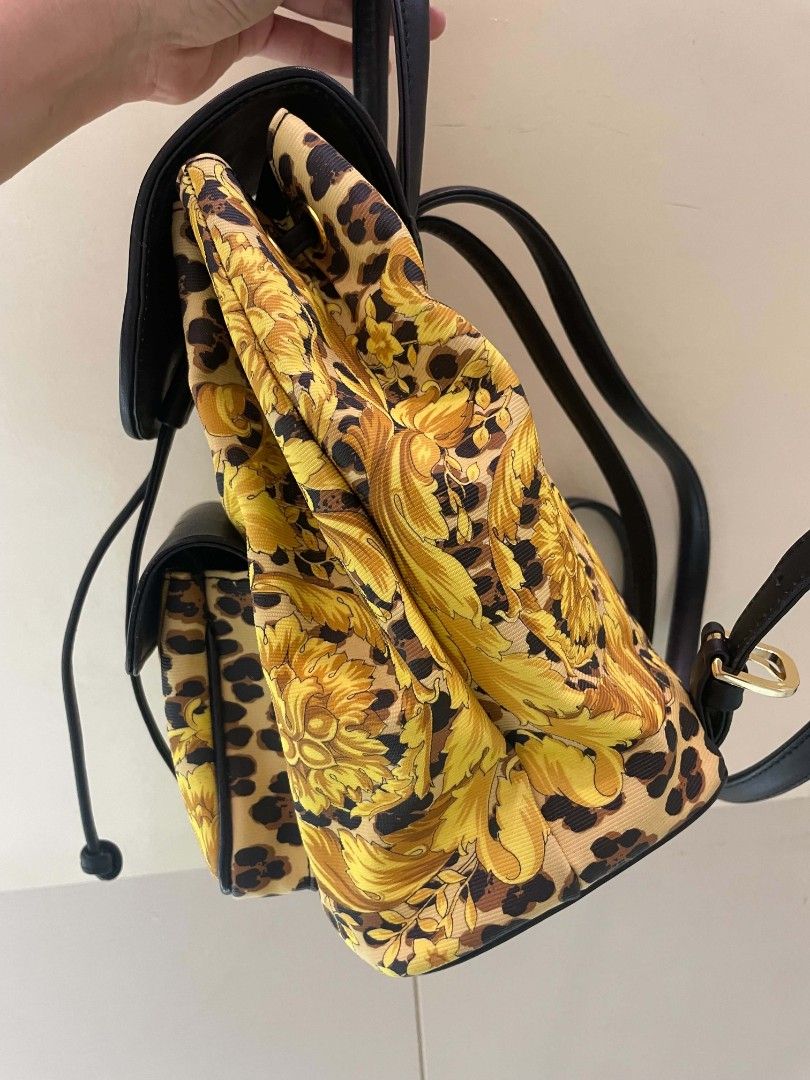 Gianni Versace (With Issue)Baroque Leopard Print Backpack (Category: Backpacks) located in Plaridel. Submitted by collectors_blocc (Listing ID 1470459362, Image 3). Description: - Brand: Gianni Versace - Design: Iconic yellow baroque and leopard print all-over pattern - Materials: Durable canvas body with premium black leather trim - Hardware: Luxurious golden hardware detailing - Closure: Front flap closure with secure drawstring pull - Pockets: