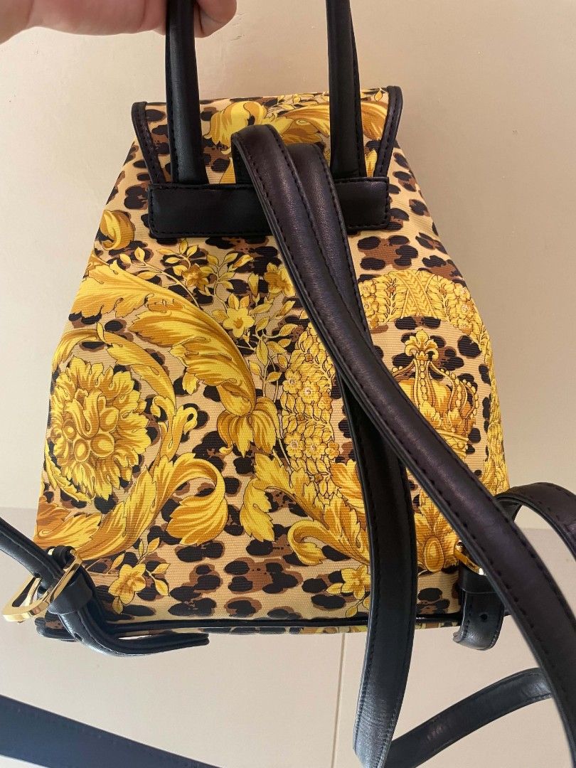 Gianni Versace (With Issue)Baroque Leopard Print Backpack (Category: Backpacks) located in Plaridel. Submitted by collectors_blocc (Listing ID 1470459362, Image 2). Description: - Brand: Gianni Versace - Design: Iconic yellow baroque and leopard print all-over pattern - Materials: Durable canvas body with premium black leather trim - Hardware: Luxurious golden hardware detailing - Closure: Front flap closure with secure drawstring pull - Pockets: