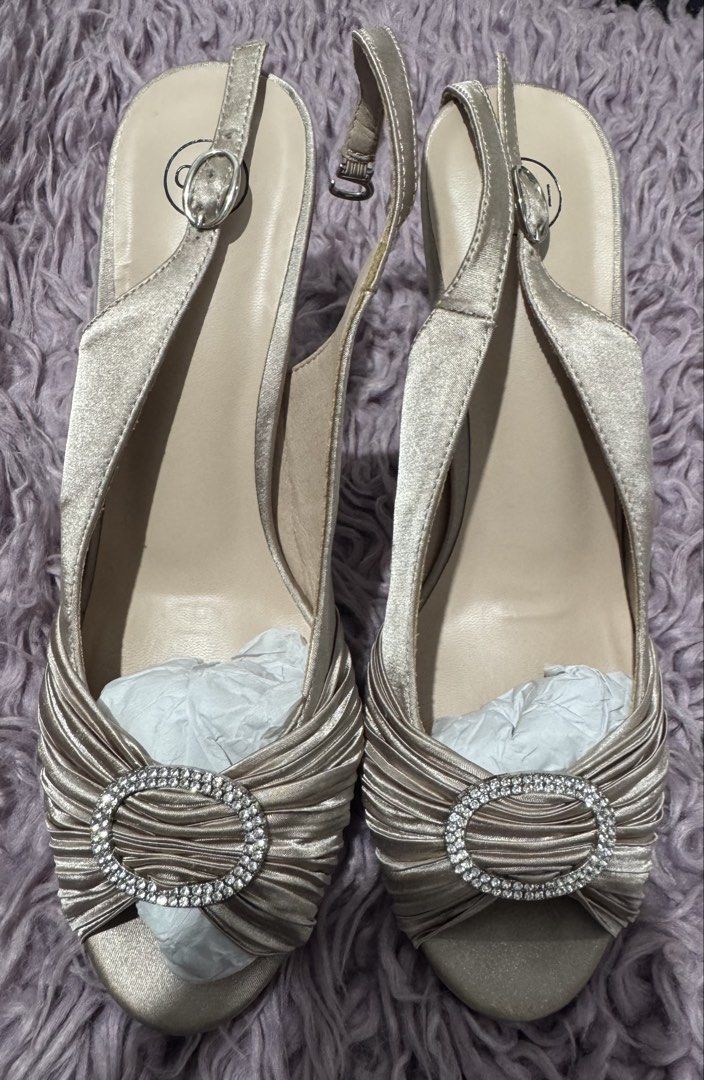 Gibi Gold Satin Slingback Heels Size 38 (Category: Heels) located in Cabanatuan. Submitted by dyosasalupa (Listing ID 1470507875, Image 3). Description: - Brand: Gibi - Style: VIVY (Gold Satin Slingback Heels) - Size: 38 (marked on sole) - Design: Ruched toe strap with a center sparkly rhinestone buckle - Features: Adjustable slingback strap with silver-toned hardware, stiletto heel with black protective tips - Condition: Clean insoles and textur