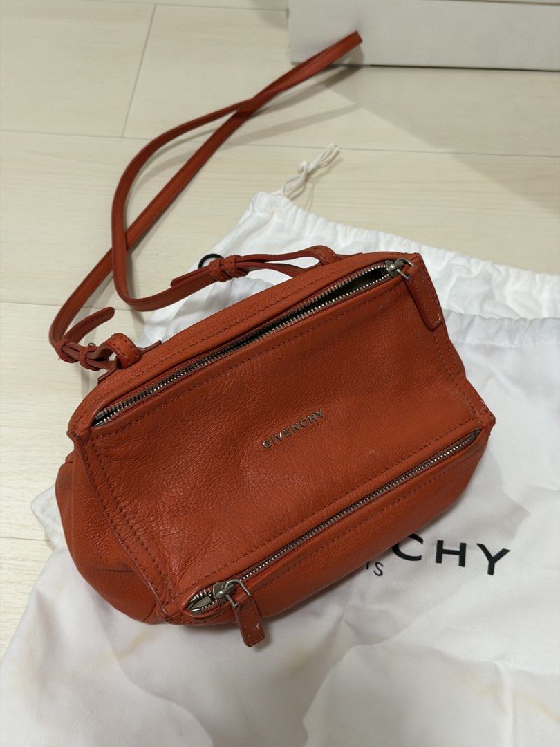 Givenchy Orange Leather Mini Pandora Crossbody Bag (Category: Luxury Bags & Wallets) located in Las Pinas. Submitted by reijeancaraig (Listing ID 1470468050, Image 1). Description: - Brand: Givenchy Pandora - Color: Vibrant orange - Material: Premium leather with neutral canvas interior - Hardware: Silver-tone with subtle front metal logo - Design: Distinctive cubist shape with top zip and front zip pocket - Strap: Long adjustable shoulder strap 