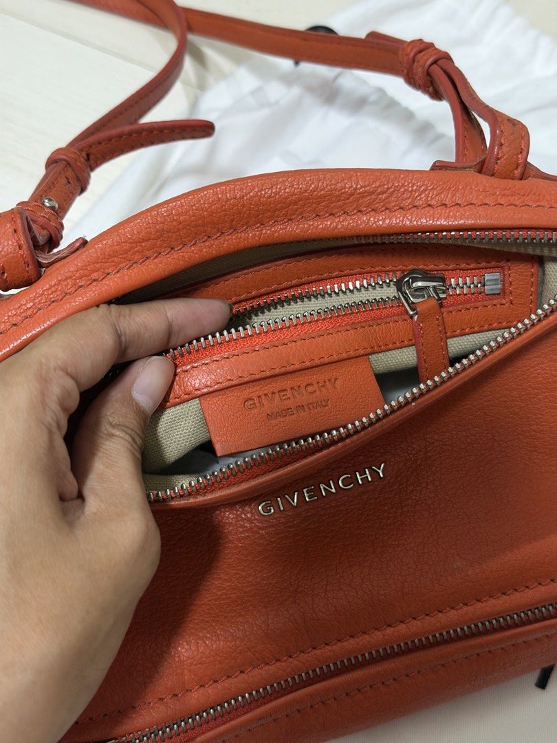 Givenchy Orange Leather Mini Pandora Crossbody Bag (Category: Luxury Bags & Wallets) located in Las Pinas. Submitted by reijeancaraig (Listing ID 1470468050, Image 2). Description: - Brand: Givenchy Pandora - Color: Vibrant orange - Material: Premium leather with neutral canvas interior - Hardware: Silver-tone with subtle front metal logo - Design: Distinctive cubist shape with top zip and front zip pocket - Strap: Long adjustable shoulder strap 