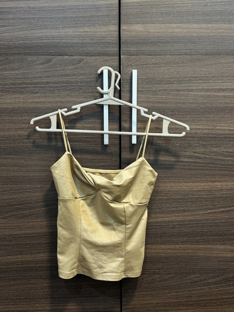 Gold satin spaghetti strap crop top with twist front (Category: Sleeveless) located in Manila. Submitted by katrinakatee (Listing ID 1470532454, Image 1). Description: - Color/Material: Luxurious gold satin - Design: Thin spaghetti straps with a stylish twist detail at the bust - Fit: Fitted silhouette with structured panels and a straight hem - Styling: Perfect for night outs or pairing with high-waisted jeans - Condition: Clean finish, ready to