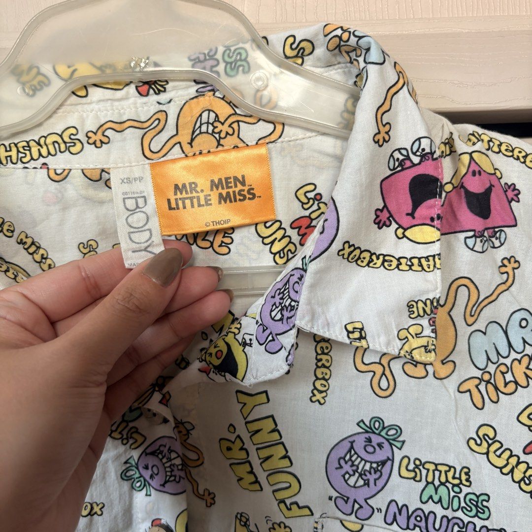 Graphic Polo Top (Category: Shirts) located in Makati City. Submitted by iu__00 (Listing ID 1470444451, Image 2). Description: - Design: Fun all-over print featuring classic Mr. Men and Little Miss characters like Mr. Tickle and Little Miss Sunshine - Color: White base with vibrant, colorful cartoon graphics - Features: Classic collar, short sleeves, front button closure, and a single chest pocket - Size: XS on tag (runs big) - Condition: Great f