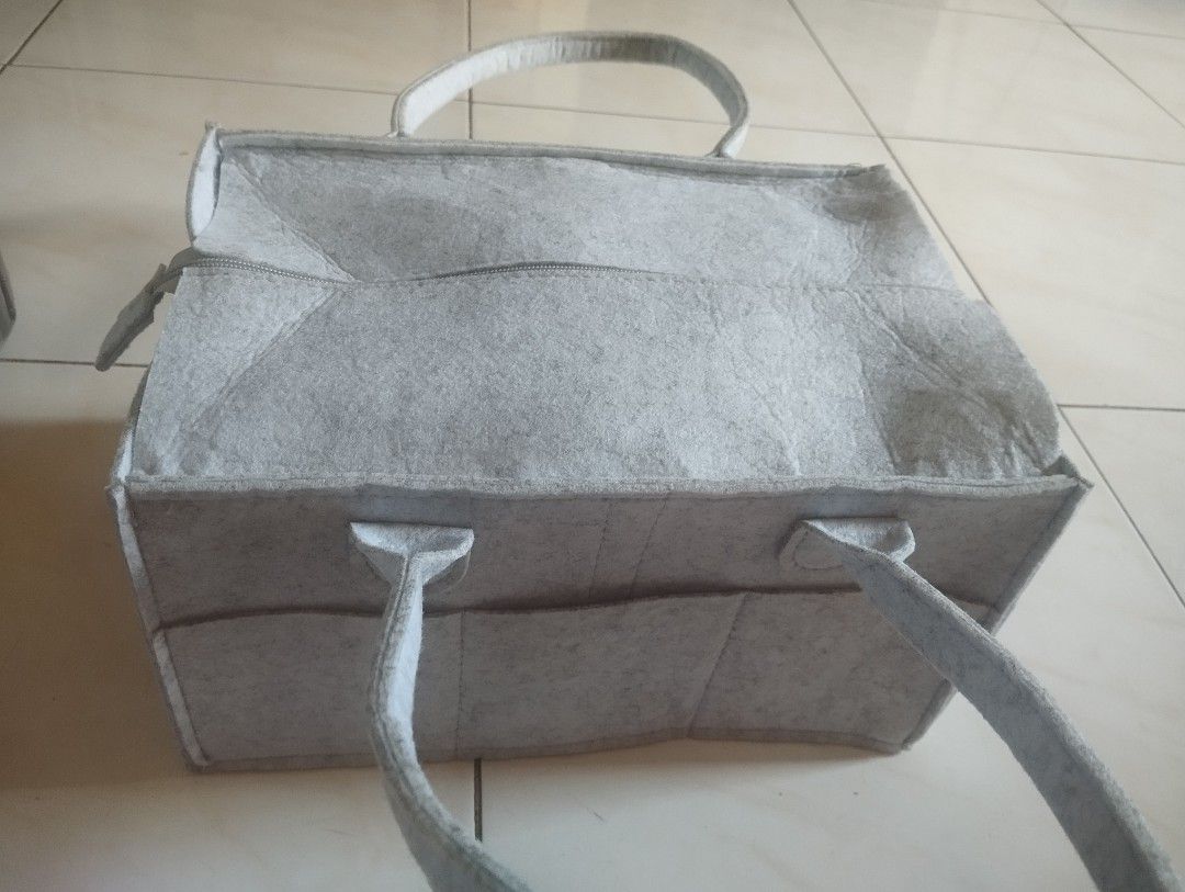 Grey felt diaper organizer storage caddy bag with zip (Category: Diaper Bags & Wetbags) located in Manila. Submitted by ljaneee (Listing ID 1470364306, Image 1). Description: - Color & Material: Premium grey felt - Closure: Secure top zipper to keep items safe - Organization: Multiple exterior front pockets and customizable interior with removable dividers - Portability: Sturdy built-in handles for easy carrying - Versatility: Perfect for baby nu