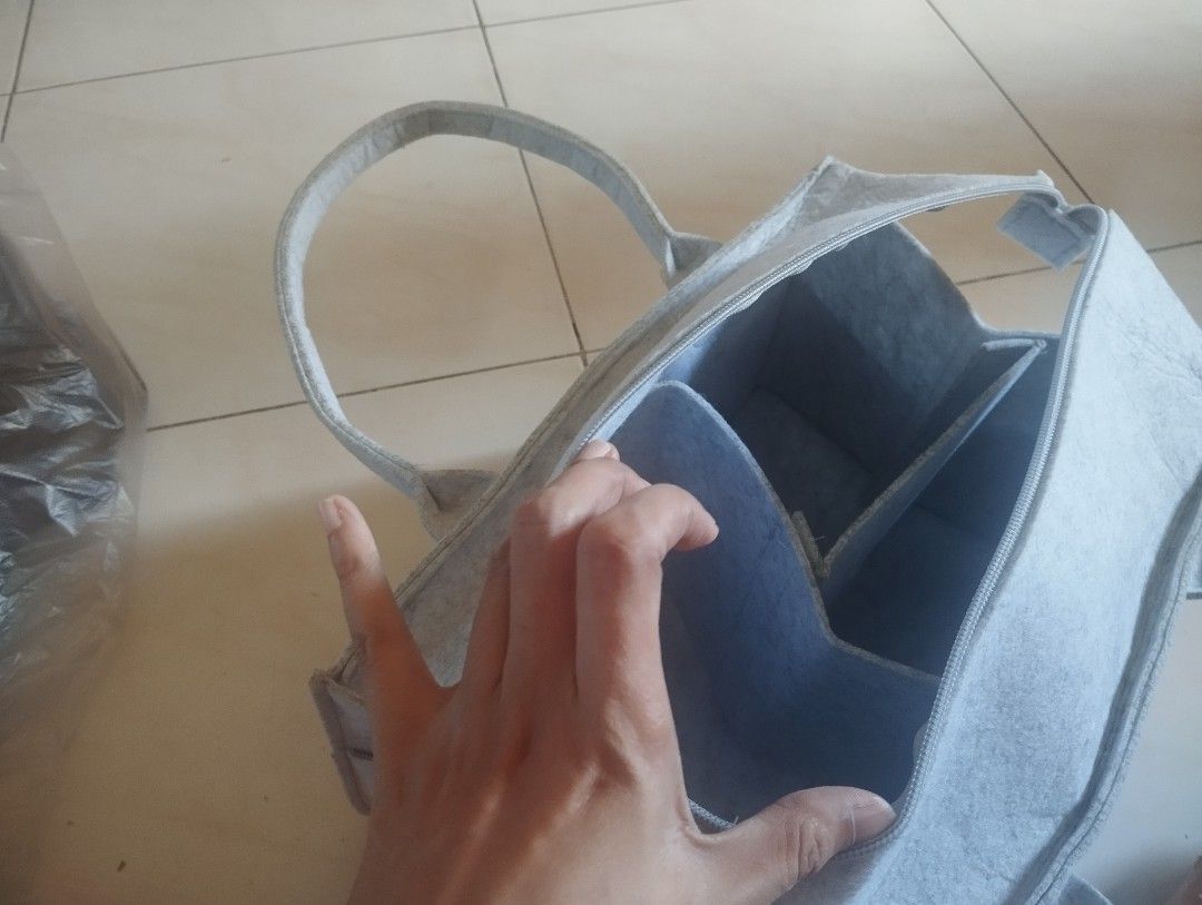 Grey felt diaper organizer storage caddy bag with zip (Category: Diaper Bags & Wetbags) located in Manila. Submitted by ljaneee (Listing ID 1470364306, Image 2). Description: - Color & Material: Premium grey felt - Closure: Secure top zipper to keep items safe - Organization: Multiple exterior front pockets and customizable interior with removable dividers - Portability: Sturdy built-in handles for easy carrying - Versatility: Perfect for baby nu