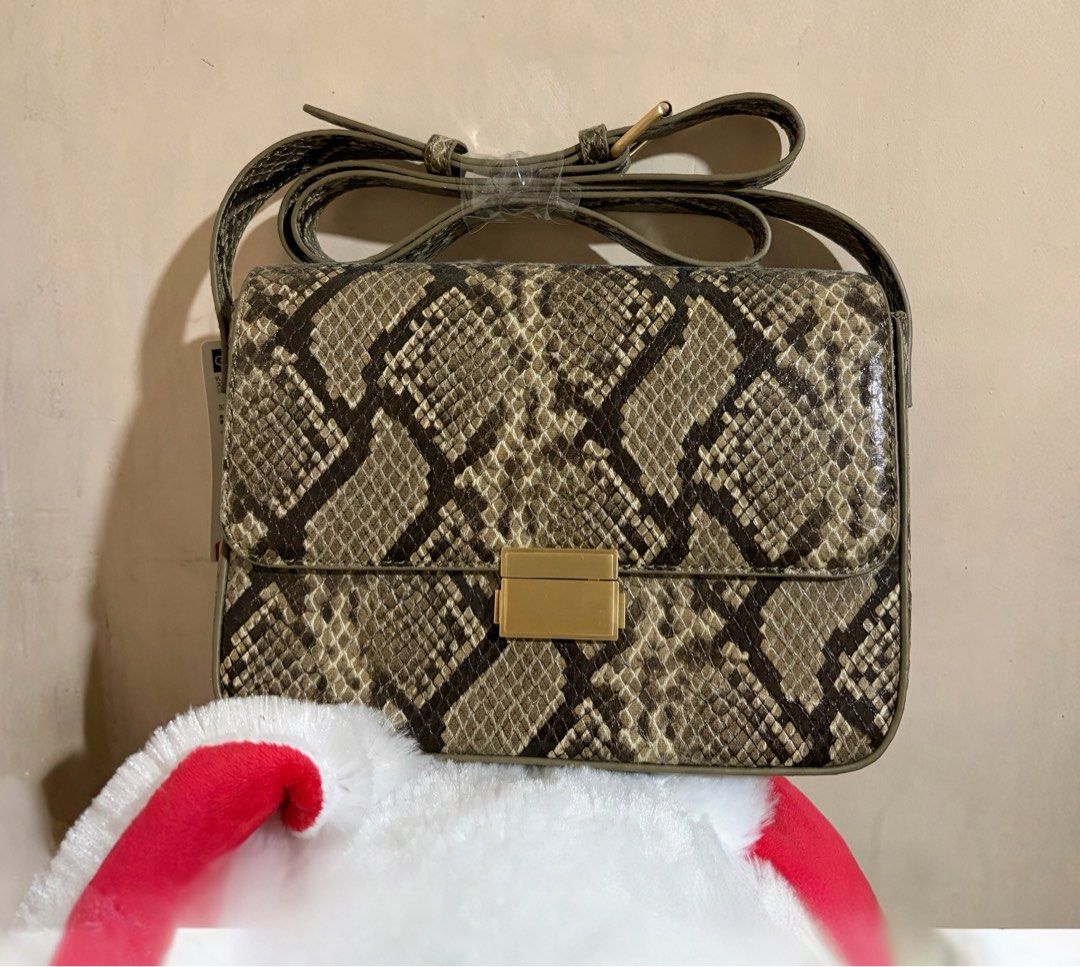 GU Square Flap Snake Print Shoulder Bag Beige (Category: Cross-body Bags) located in Quezon City. Submitted by mayangski77 (Listing ID 1470360376, Image 1). Description: - Brand new with original store tags - Trendy snake print design in beige (Color 32) - Secure magnetic clasp closure - Convenient adjustable crossbody strap - Material: Synthetic leather - Size: One size fits all.