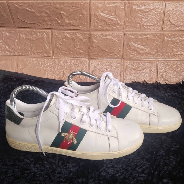 Gucci Ace Embroidered Bee Sneakers (Category: Sneakers) located in Lubao. Submitted by dione_closet503 (Listing ID 1470355754, Image 1). Description: - Authentic Gucci Ace sneakers in white leather - Features iconic green and red web stripe with gold embroidered bee - Metallic snake-print heel patch detail - Clean uppers with only minor wear on the soles - Timeless designer style that pairs effortlessly with any casual outfit - Message for inquir