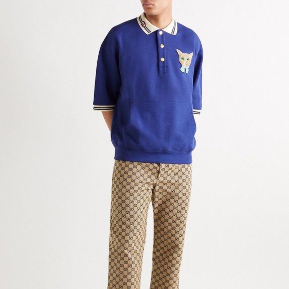 Gucci Cat Patch Blue Polo Shirt (Category: Tshirts & Polo Shirts ) located in Buenavista. Submitted by ivoperez27 (Listing ID 1470403768, Image 2). Description: - Brand: Gucci - 23 width 27 length - Color: Deep royal blue with cream and striped contrasting trims - Details: Embroidered interlocking G logo on collar, gold-tone Gucci-stamped buttons, and cute embroidered cat face patch with a light blue bow - Pockets: Front kangaroo pocket - Fit: Re