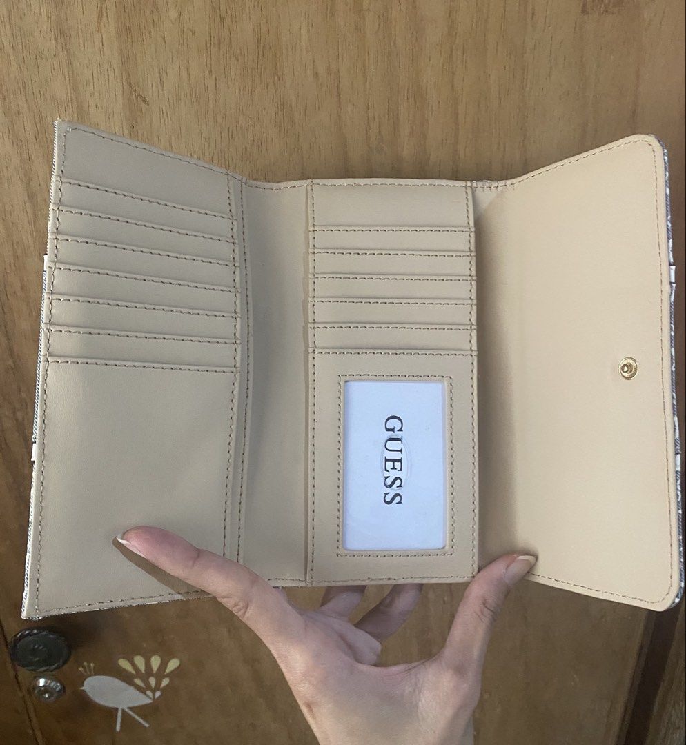 Guess Blue Monogram Denim Wallet (Category: Wallets & Card holders) located in Bulacan. Submitted by madchen05 (Listing ID 1470360203, Image 3). Description: Guess Blue Monogram Denim Wallet 🌟Size: Medium 🌟Hardware: Gold-tone front logo and branded zipper pull on the back pocket 🌟Interior: Beige lining with multiple card slots and an ID window 🌟Condition: Good as new 🌟Flaw: Minor dark smudge spot on the front left fabric 🌟P2,000.00 only + d
