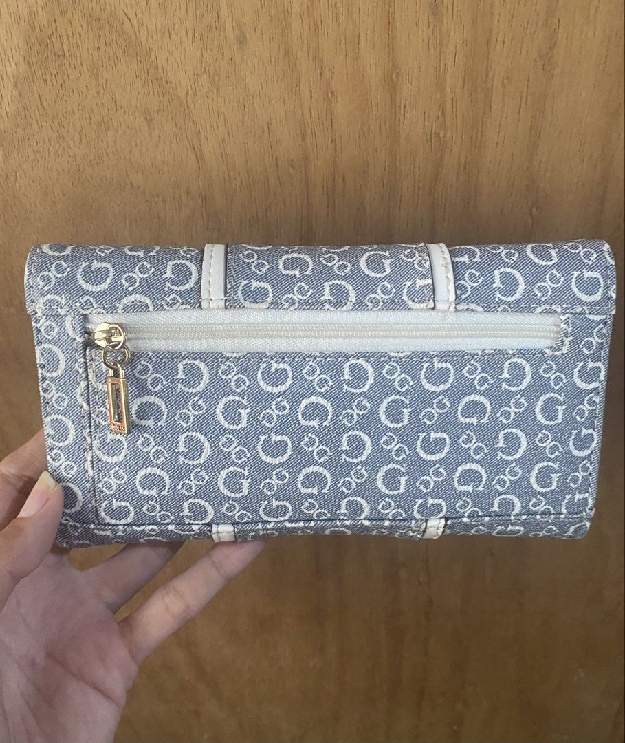 Guess Blue Monogram Denim Wallet (Category: Wallets & Card holders) located in Bulacan. Submitted by madchen05 (Listing ID 1470360203, Image 2). Description: Guess Blue Monogram Denim Wallet 🌟Size: Medium 🌟Hardware: Gold-tone front logo and branded zipper pull on the back pocket 🌟Interior: Beige lining with multiple card slots and an ID window 🌟Condition: Good as new 🌟Flaw: Minor dark smudge spot on the front left fabric 🌟P2,000.00 only + d