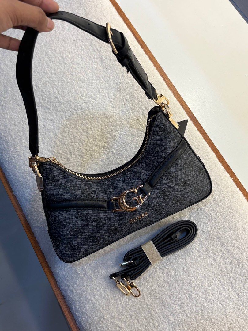 Guess Dea Top Zip Shoulder Bag (Category: Shoulder Bags) located in Taguig. Submitted by 02ruedasrh20304 (Listing ID 1470465050, Image 1). Description: - Authentic Guess shoulder bag in sleek black monogram design. - Features eye-catching gold-tone hardware and prominent front G logo buckle. - Clean cream fabric interior with repeating Guess branding. - Includes practical interior zip pocket and slip compartments. - Comes with an extra brand-new 