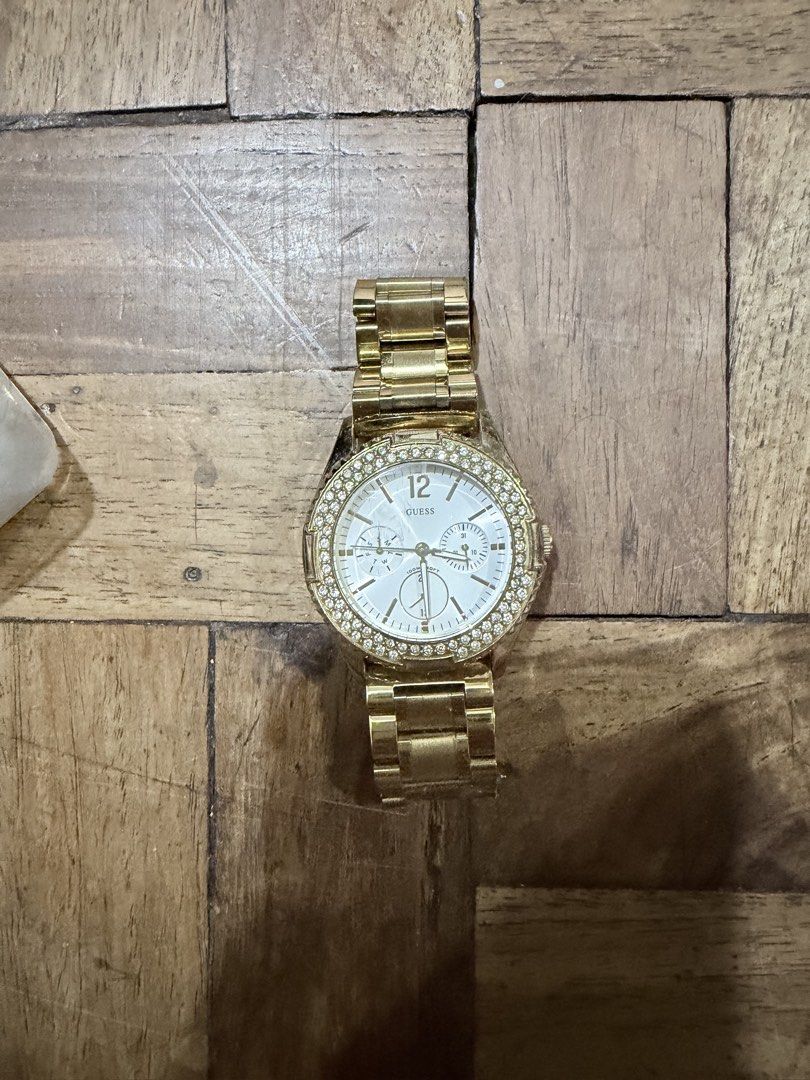 Guess Gold Rhinestone Chronograph Watch (Category: Women's Watches) located in Paranaque City. Submitted by hannahking36 (Listing ID 1470555103, Image 1). Description: - Brand: Guess - Color: Shiny gold tone - Face: Round with sparkling crystal bezel - Dial: White with clear number markers and 3 sub-dials - Strap: Matching link bracelet with secure clasp - Movement: Battery-operated quartz - Condition: Minimal wear on links from normal use, excel