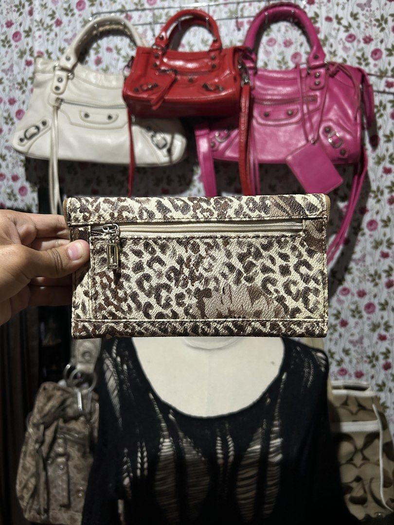 Guess Leopard Animal Print Long Wallet (Category: Wallets & Card holders) located in Los Banos. Submitted by samsukehiro (Listing ID 1470471400, Image 2). Description: Guess long wallet in animal print pattern. Brown and beige tones with gold hardware lock closure on the front flap. Back has a zippered pocket for coins or small items. Interior features multiple card slots, bill compartments, and a clear ID window. Fold-over snap closure keeps eve