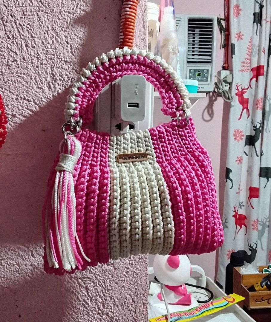 Handmade Crochet Handbag Pink and White (Category: Shoulder Bags) located in Manila. Submitted by dalusongro28706 (Listing ID 1470472233, Image 1). Description: - Handmade crochet handbag in hot pink and off-white yarn - Structured top handle design with a stylish vertical rib texture - Includes a matching tassel charm on the side ring - Finished with a small metal "handmade" label on the front - Perfect pop of color for your daily OOTDs.