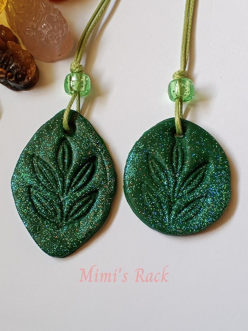 Handmade Green Glitter Leaf Clay Rope Necklace (Category: Necklaces) located in Taguig. Submitted by mimisrack (Listing ID 1470498196, Image 3). Description: 💚Add a touch of nature-inspired sparkle to your everyday look! This eye-catching necklace features a dark green leaf-shaped pendant with a beautifully embossed leaf design and dazzling multicolored glitter. Paired with a matching green cord and translucent green accent beads, it has a uniqu