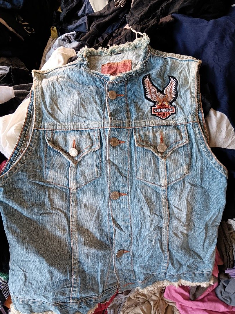 Harley Davidson Denim Vest With Eagle Patch (Category: Coats, Jackets and Outerwear) located in Cagayan de Oro. Submitted by kokirts17 (Listing ID 1470395242, Image 2). Description: - Style: Vintage light wash denim vest with a classic biker look - Details: Sleeveless with trendy raw frayed edges at the collar and armholes - Embroidery: Large Harley Davidson eagle patch on the back and a smaller one on the front chest pocket - Closure & Pockets: 