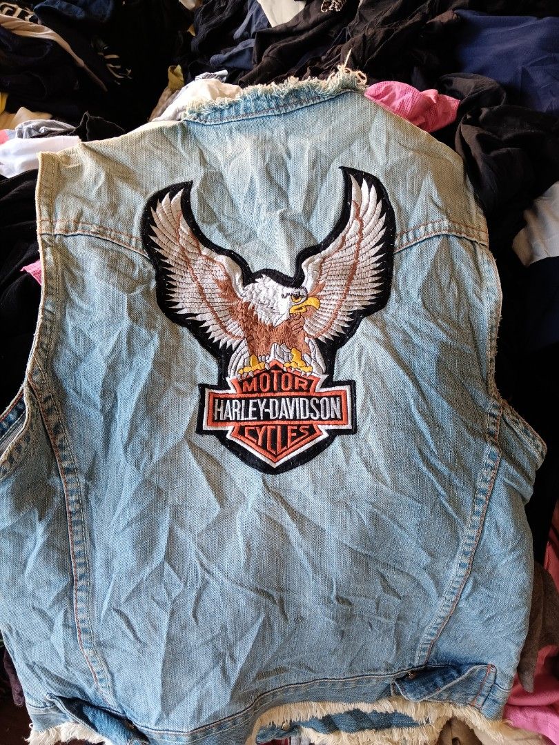 Harley Davidson Denim Vest With Eagle Patch (Category: Coats, Jackets and Outerwear) located in Cagayan de Oro. Submitted by kokirts17 (Listing ID 1470395242, Image 1). Description: - Style: Vintage light wash denim vest with a classic biker look - Details: Sleeveless with trendy raw frayed edges at the collar and armholes - Embroidery: Large Harley Davidson eagle patch on the back and a smaller one on the front chest pocket - Closure & Pockets: 