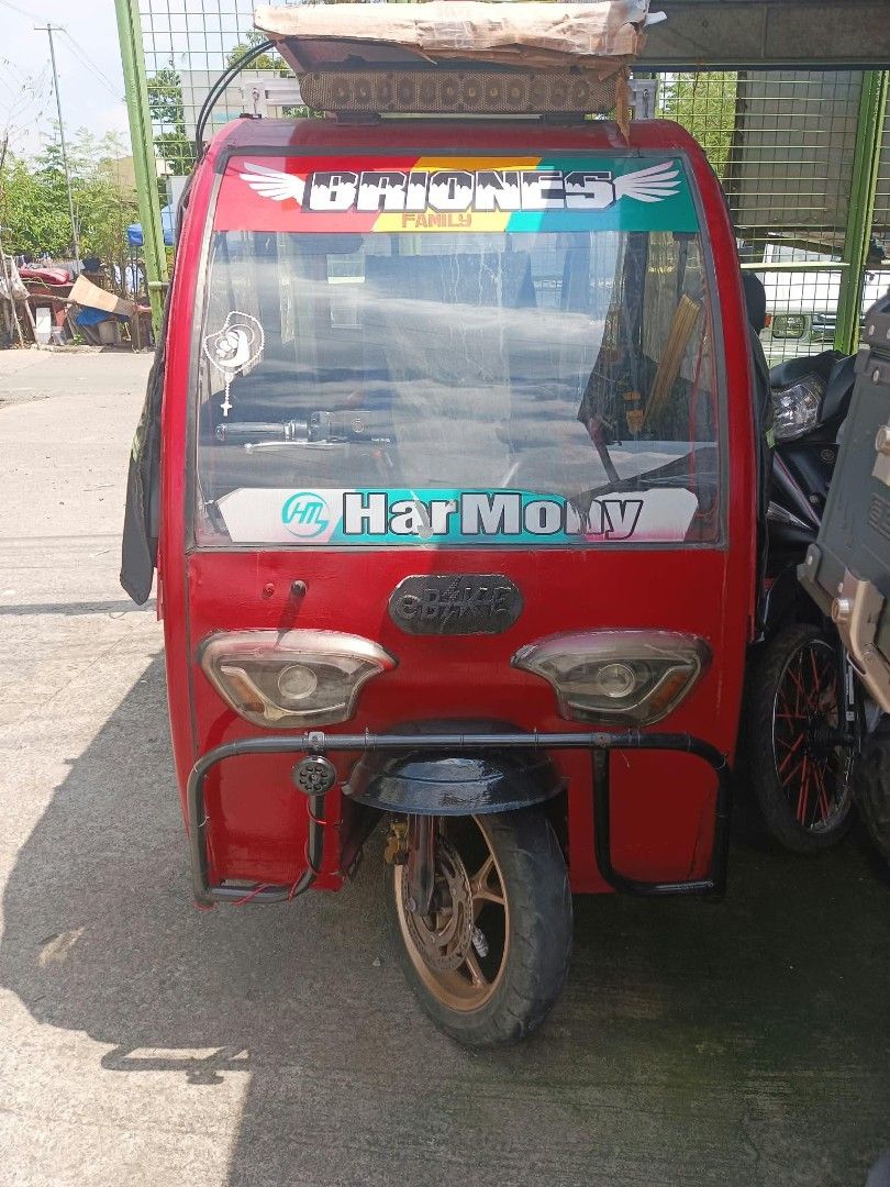 HARMONY E BIKE (Category: Motorbikes for Sale) located in Manila. Submitted by dj_deung (Listing ID 1470495472, Image 1). Description: HARMONY BRAND - Color: Striking red with blue upholstered seating - Power: De charge and also Eco-friendly roof-mounted solar panel setup kaya malakas ang hatak. - Enclosure: Black side curtains featuring clear plastic windows pwede for 3 adult passengers or pwede panghakot. - Protection & Lighting: Front bullbar 
