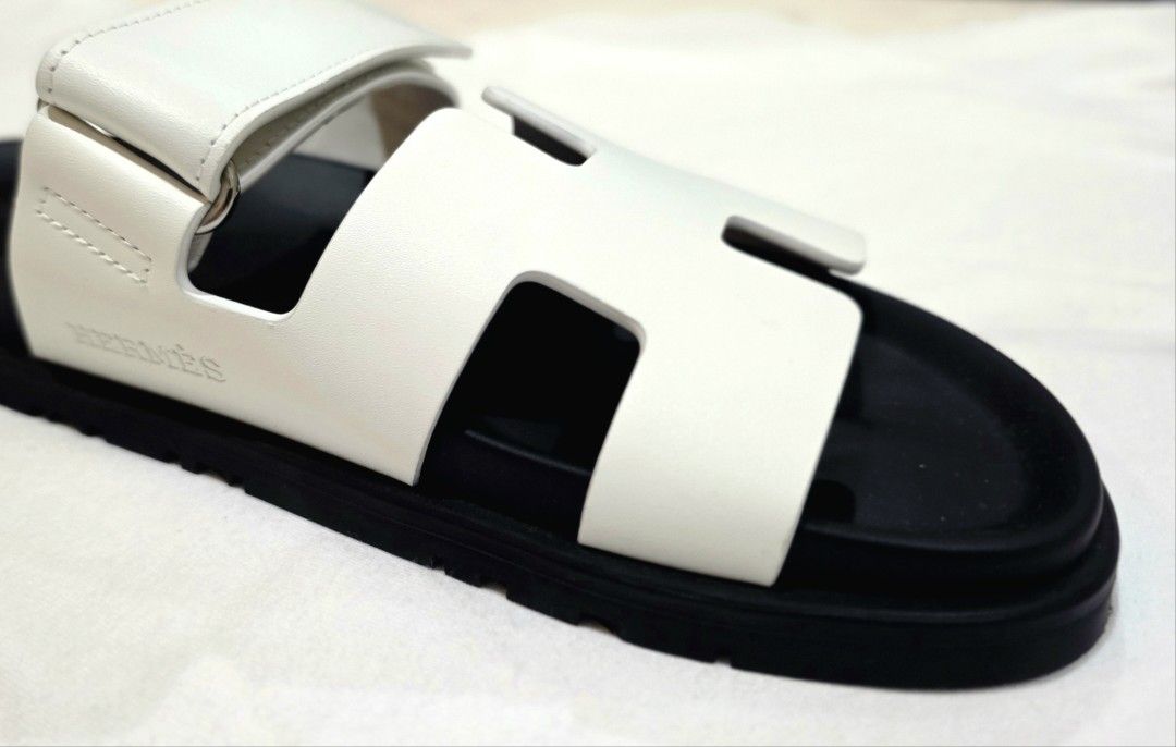 Hermès Chypre Sandal White Black (Category: Sneakers & Footwear) located in Quezon City. Submitted by go_astley08 (Listing ID 1470358028, Image 1). Description: - Brand: Hermès - Model: Chypre Sandals - Color: White leather with black rubber soles - Design: Iconic cut-out H strap with adjustable velcro back strap - Details: Debossed Hermès logo on the side and footbed - Condition/Inclusions: Comes with original orange box and dust bag - Features: