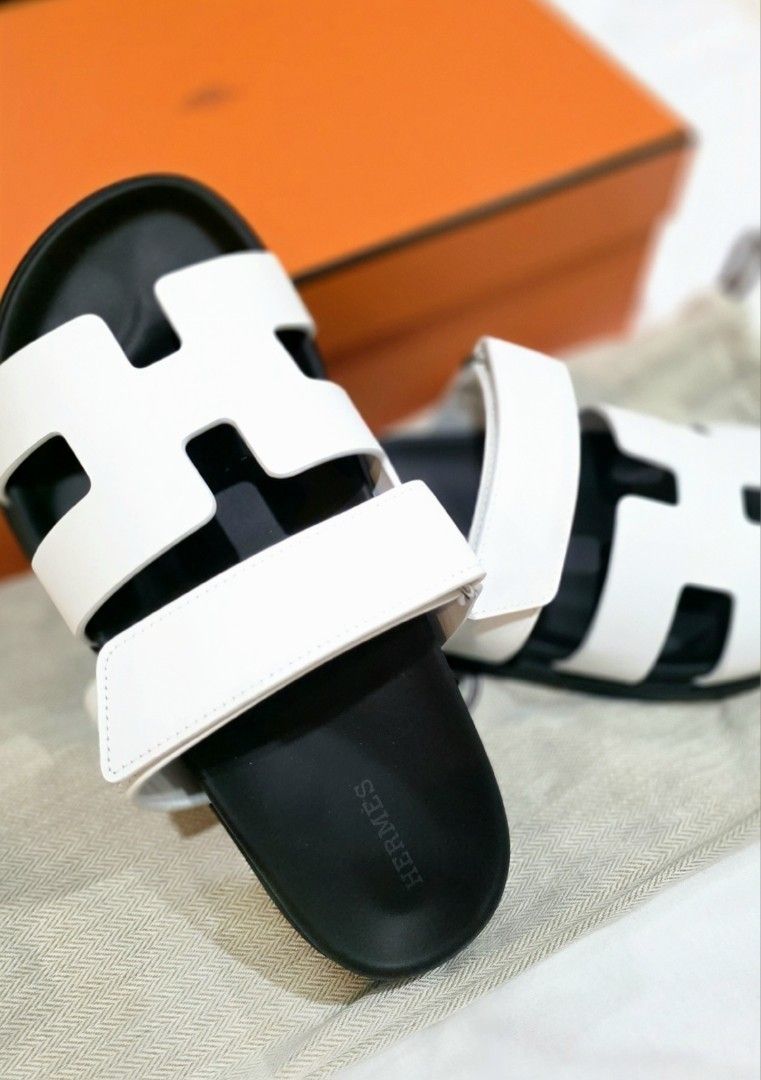 Hermès Chypre Sandal White Black (Category: Sneakers & Footwear) located in Quezon City. Submitted by go_astley08 (Listing ID 1470358028, Image 3). Description: - Brand: Hermès - Model: Chypre Sandals - Color: White leather with black rubber soles - Design: Iconic cut-out H strap with adjustable velcro back strap - Details: Debossed Hermès logo on the side and footbed - Condition/Inclusions: Comes with original orange box and dust bag - Features: