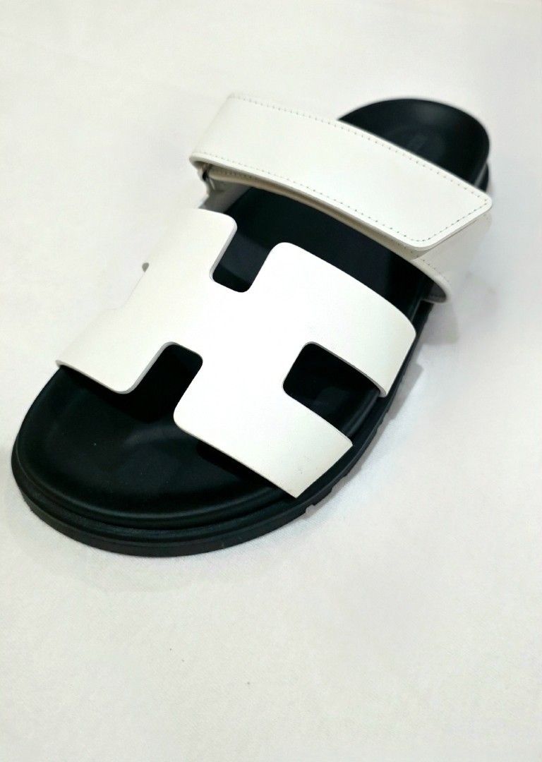 Hermès Chypre Sandal White Black (Category: Sneakers & Footwear) located in Quezon City. Submitted by go_astley08 (Listing ID 1470358028, Image 2). Description: - Brand: Hermès - Model: Chypre Sandals - Color: White leather with black rubber soles - Design: Iconic cut-out H strap with adjustable velcro back strap - Details: Debossed Hermès logo on the side and footbed - Condition/Inclusions: Comes with original orange box and dust bag - Features: