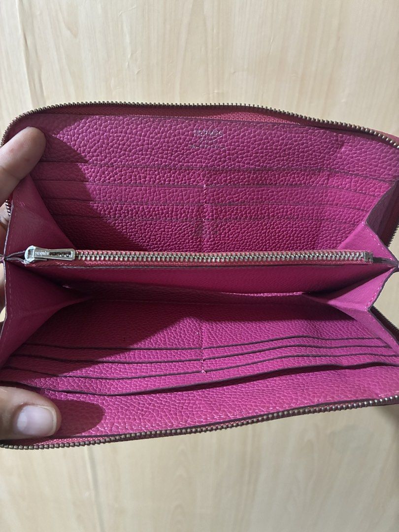 Hermès Silk'In Azap Long Wallet Pink (Category: Wallets & Card holders) located in Placer. Submitted by talaalond61563 (Listing ID 1470419655, Image 3). Description: - Brand: Hermès - Material: Grainy leather in bright pink with matching interior lining - Design: Iconic perforated 'H' logo on the front - Hardware: Silver-tone with engraved logo pull - Compartments: Multiple card slots and secure inner zippered pocket - Condition: Good pre-loved c
