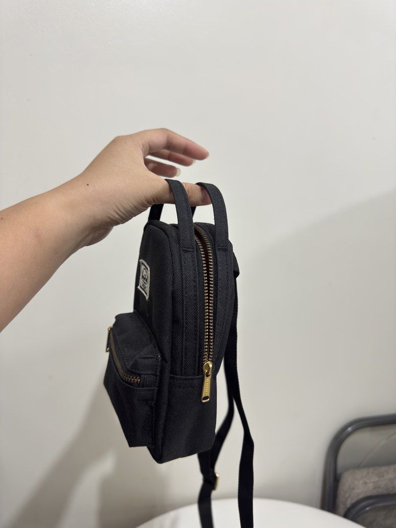Herschel Supply Co. Mini Black Crossbody Backpack (Category: Cross-body Bags) located in Quezon City. Submitted by decluttergirlie (Listing ID 1470546614, Image 3). Description: - Authentic black Herschel mini backpack / crossbody bag - Brass zipper hardware and iconic branded label patch - Adjustable black strap and convenient top haul handle - Signature red and white striped fabric interior with slip pocket and branded tag - Compact and lightwe