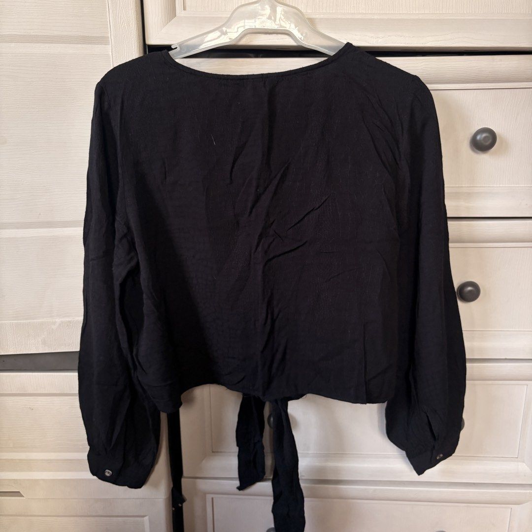 H&M Black Long Sleeve Tie Front Blouse (Category: Longsleeves) located in Makati City. Submitted by iu__00 (Listing ID 1470445075, Image 3). Description: - Brand: H&M - Color: Black - Size: Med - Style: Long sleeve crop top with V-neckline and button-front closure - Details: Trendy self-tie hem and lightweight textured fabric - Condition: Great pre-loved/new basic piece for layering or standalone wear.