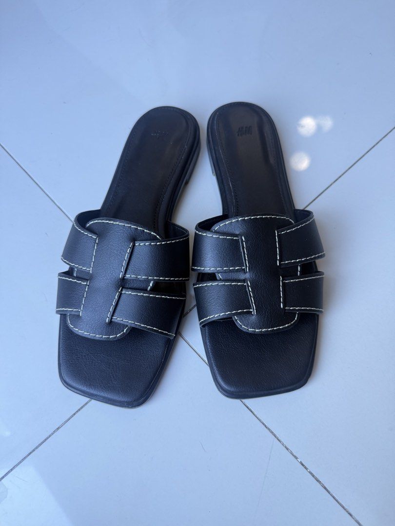 H&M Black Slide Sandals (Category: Flats & Sandals) located in Makati City. Submitted by bcazu (Listing ID 1470356404, Image 1). Description: H&M Sandals with contrast stitching (Hermes inspired) Size: 39 RFS: Used lightly - size too big for me - Color: Black with white contrast stitching - Design: Square toes, crossover upper straps, slip-on style - Perfect for casual daily outfits Meet up at Eastwood or delivery c/o buyer.
