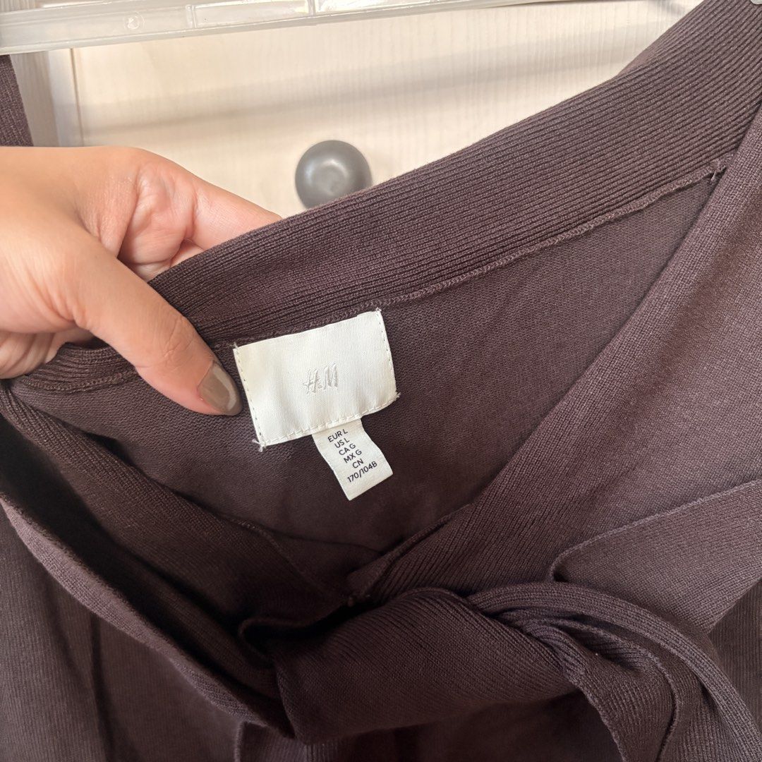 H&M Brown Knit Top with Front Tie (Category: Blouses) located in Makati City. Submitted by iu__00 (Listing ID 1470444721, Image 2). Description: - Brand: H&M - Size: Large - Color: Dark chocolate brown - Material: Stretchy ribbed knit - Design: Off-the-shoulder neckline with folded collar and cute front tie accent - Condition: Great piece, easy to style up or down.