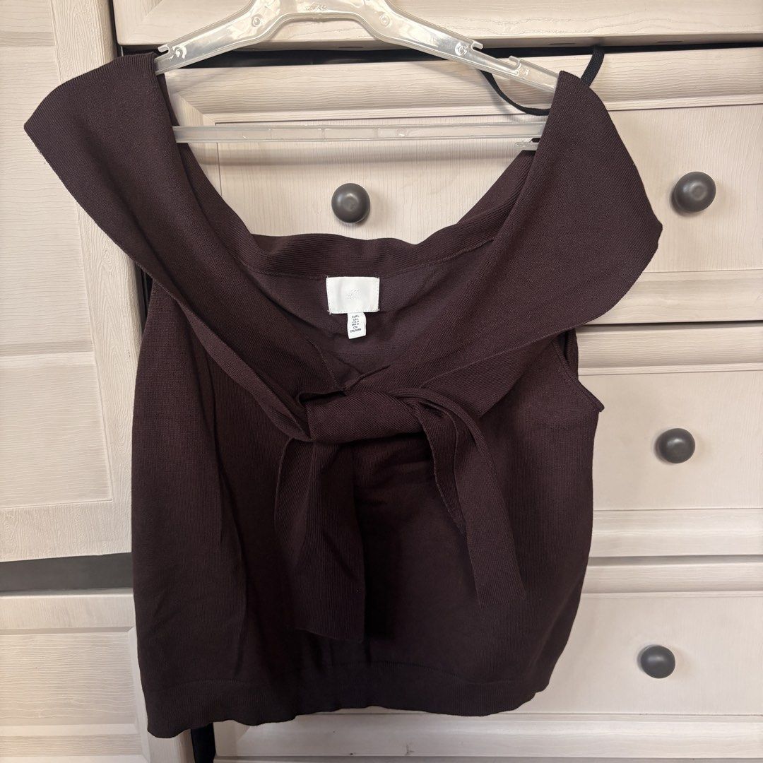 H&M Brown Knit Top with Front Tie (Category: Blouses) located in Makati City. Submitted by iu__00 (Listing ID 1470444721, Image 1). Description: - Brand: H&M - Size: Large - Color: Dark chocolate brown - Material: Stretchy ribbed knit - Design: Off-the-shoulder neckline with folded collar and cute front tie accent - Condition: Great piece, easy to style up or down.