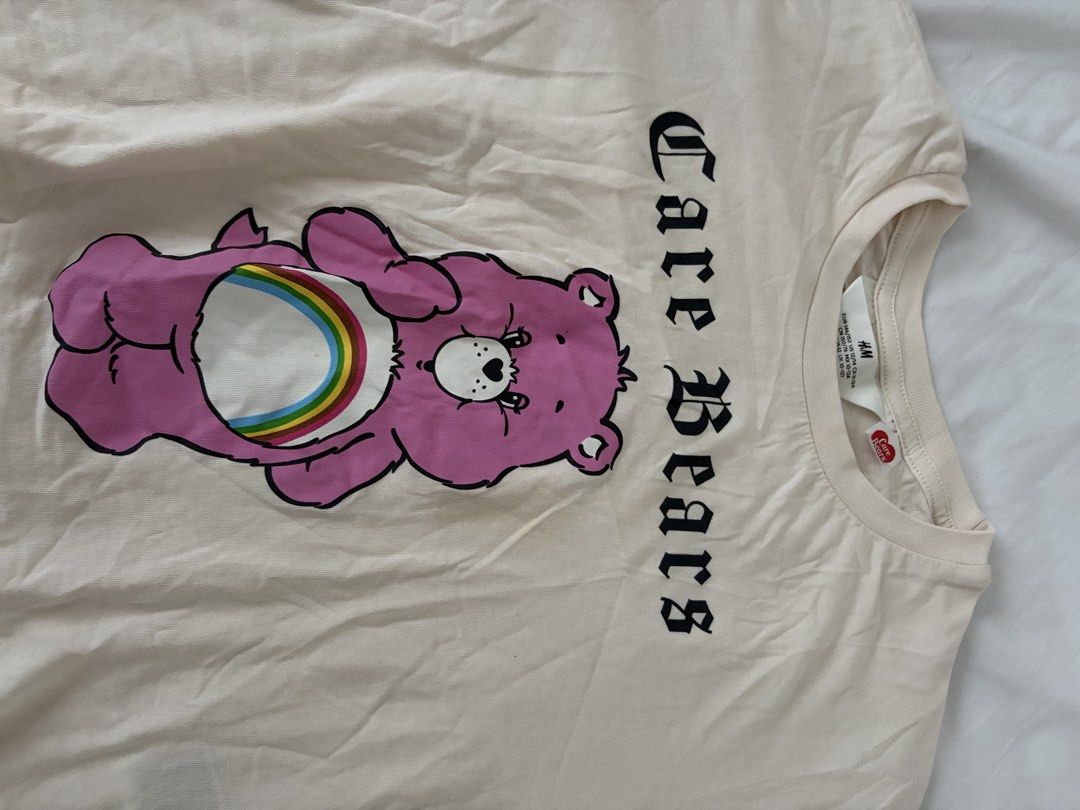 H&M Care Bears Graphic Tee Size 12-14 (Category: Shirts) located in Las Pinas. Submitted by thriftedfinds_ (Listing ID 1470354976, Image 2). Description: - Brand: H&M x Care Bears Official Collaboration - Color: Cream with large pink graphic and edgy gothic text - Size: EUR 146/152 or US 12/14 - Material: Super soft 100% cotton - Style: Short sleeve crew neck tee - Condition: Excellent, ready to ship!.