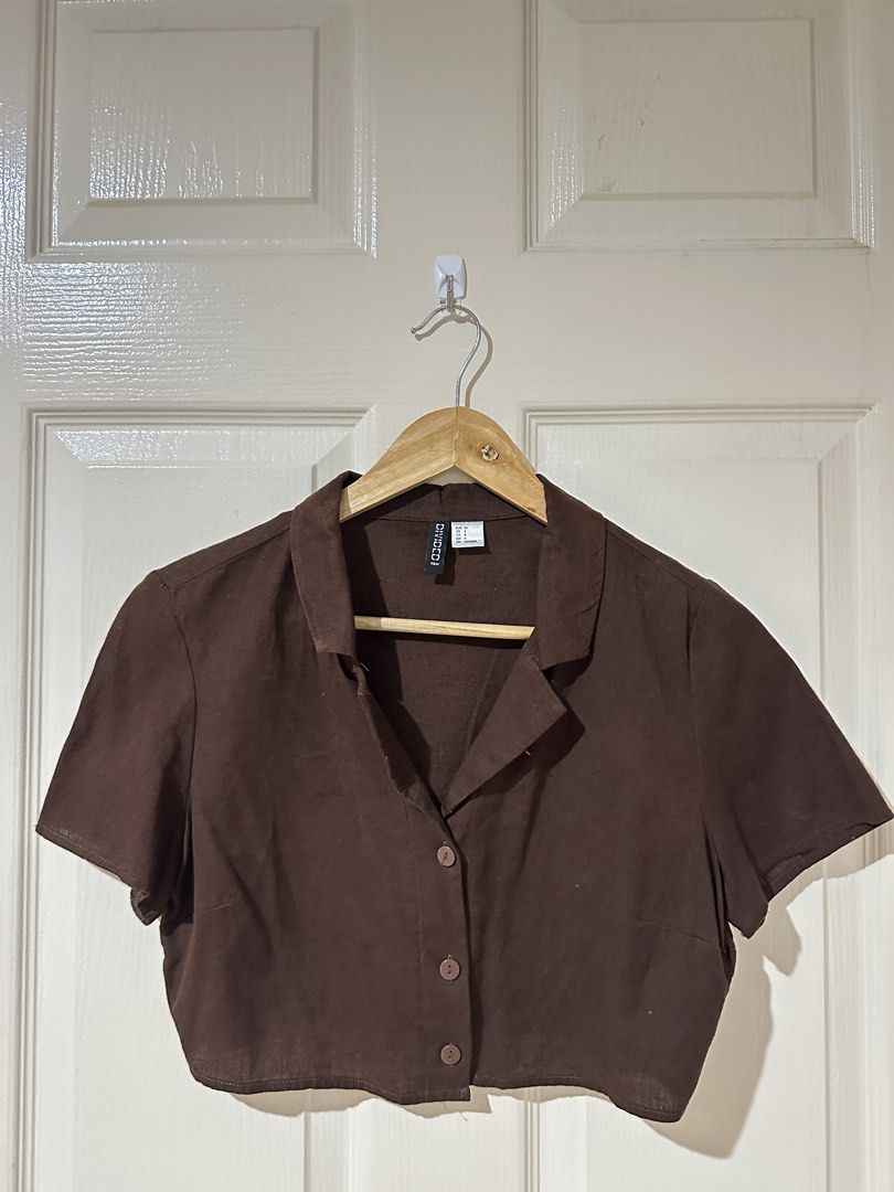 H&M Divided Brown Short Sleeve Crop Top (Category: Shirts) located in Manila. Submitted by ktyyycloset (Listing ID 1470528379, Image 2). Description: - Brand: H&M Divided - Style: Brown short sleeve crop top with collar and button-down front - Size: EUR 36 / US 4 (fits US Small approx) - Condition: Excellent, clean with no stains or damage - Perfect for pairing with high-waisted jeans or skirts.
