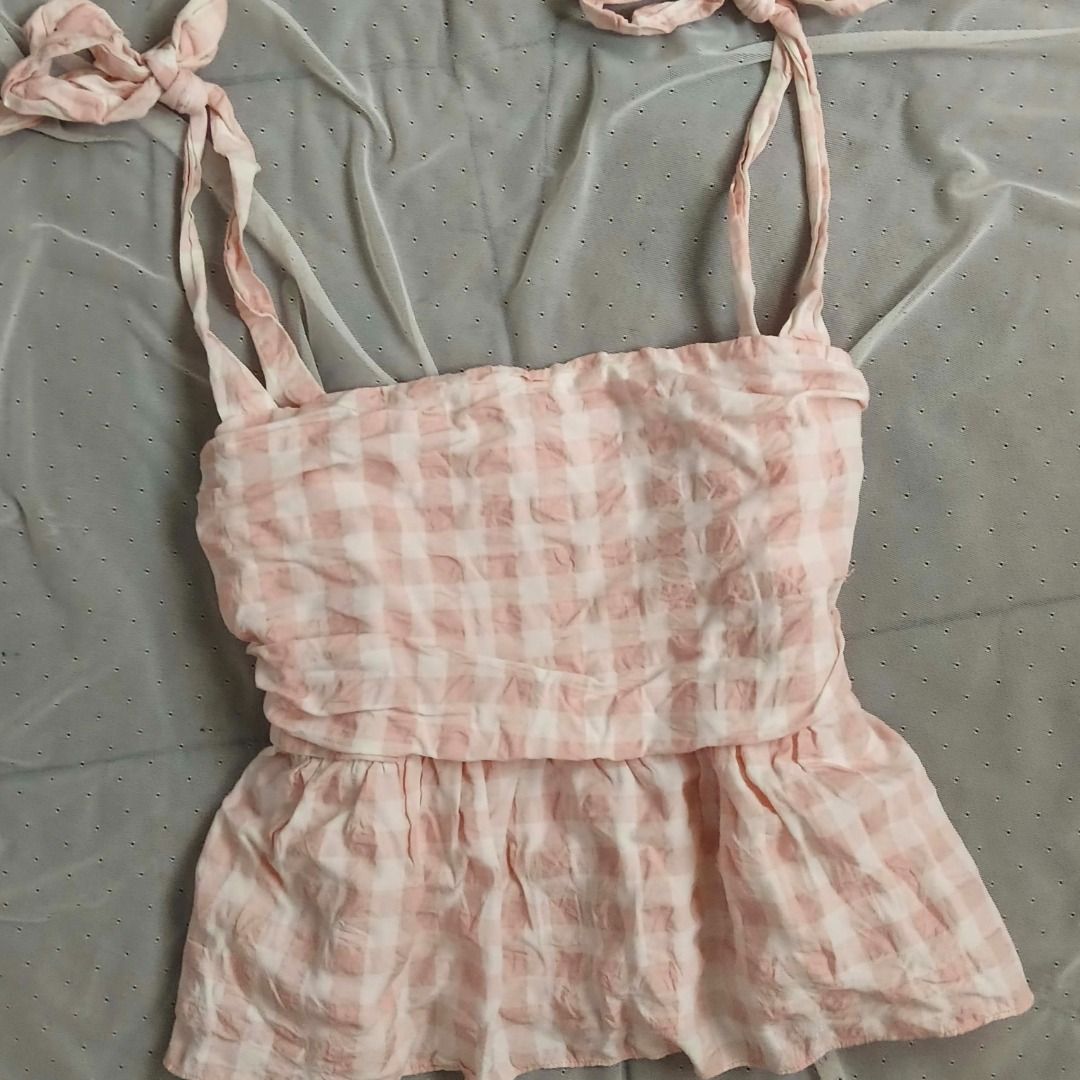 H&M Pink Gingham Tie Strap Peplum Top (Category: Sleeveless) located in Manila. Submitted by electricpetals (Listing ID 1470474907, Image 2). Description: - Design: Pink and white gingham pattern with a flared peplum hem - Straps: Self-tie ribbon straps at the shoulders - Fit & Comfort: Stretchy smocked bodice, light and textured fabric - Size: M-L .
