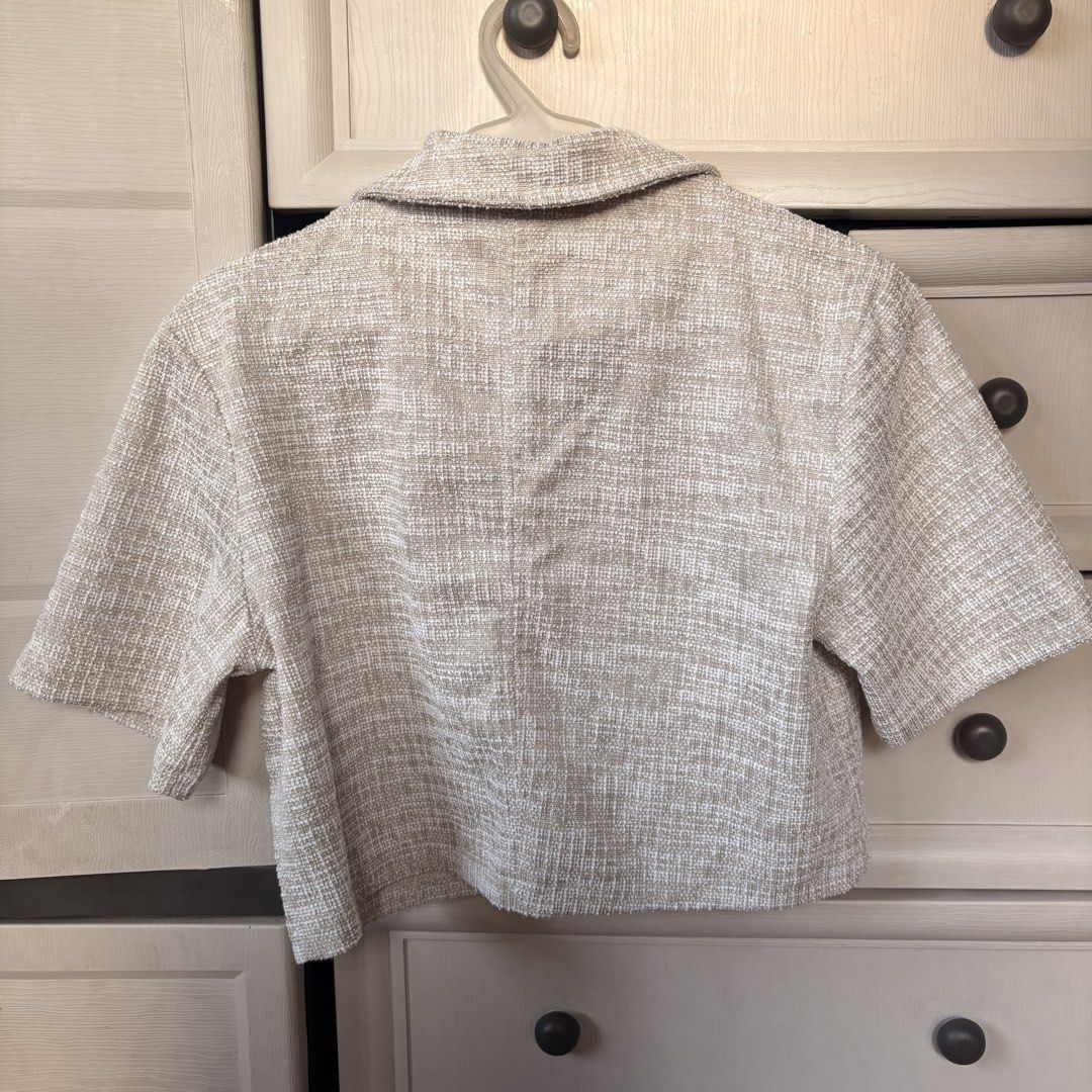H&M Tweed Crop Top (Category: Blouses) located in Makati City. Submitted by iu__00 (Listing ID 1470444194, Image 3). Description: - Brand/Model: H&M - Size: Small - Color/Fabric: Beige and white tweed - Design: Short sleeves, collar, button-down front with metallic ornate buttons - Fit: Cropped length, structured fit - Condition: Clean and well cared for - Style Tip: Great layering piece for work or going out.