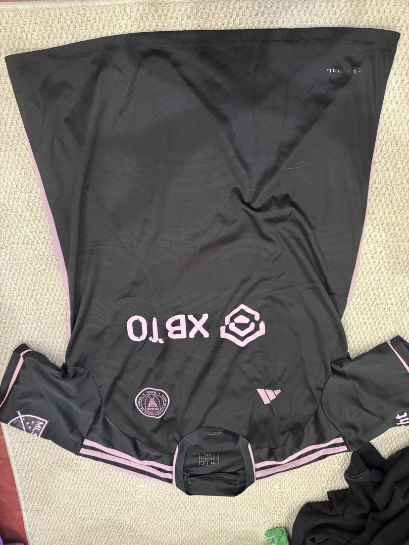 Inter Miami CF Messi 10 Away Jersey (Category: Activewear) located in Valenzuela. Submitted by crabncorn (Listing ID 1470362212, Image 1). Description: - Brand: Adidas - Team: Inter Miami CF (Away) - Player: Messi #10 printing - Size: 2XL (inner collar heat transfer tag) - Color: Black with pink accents - Features: XBTO front sponsor and official MLS sleeve patch - Condition: Brand new.