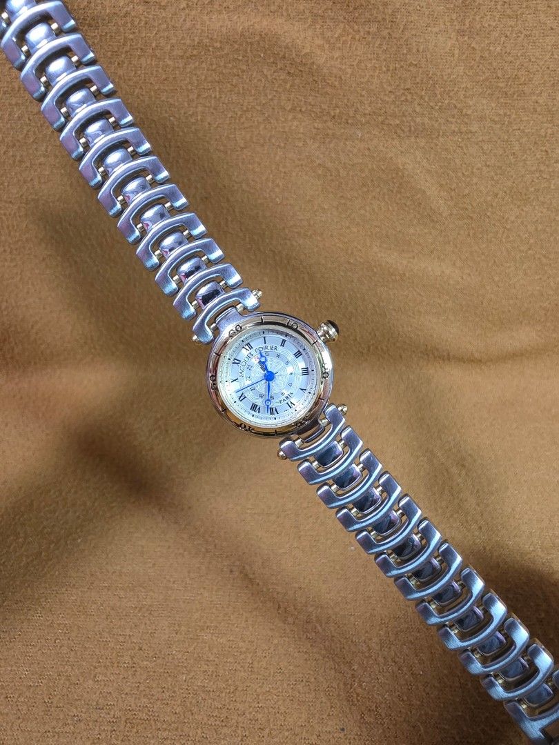 Jacques Poirier Paris Two-Tone Wristwatch (Category: Women's Watches) located in Rosales. Submitted by akumie30 (Listing ID 1470528823, Image 2). Description: - Brand: Jacques Poirier Paris - Dial: Textured silver with classic Roman numerals and inner 24-hour ring - Hands: Elegant blue hands - Details: Crown topped with a stylish dark cabochon stone - Bracelet: Two-tone links in steel and gold finish - Case Back: Stainless steel with 5 bar water 