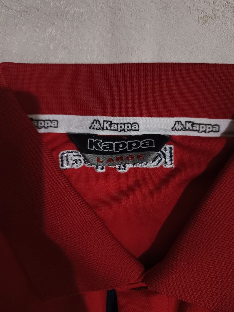 Kappa Red Polo Shirt Size L (Category: Tshirts & Polo Shirts ) located in Davao. Submitted by jjj_mncd (Listing ID 1470528835, Image 3). Description: - Brand: Kappa - Color: Red with dark blue and white chest stripe - Size: Large (Tagged) - Material: 100% Polyester (Made in Korea) - Style: Classic polo with short sleeves, collar, and button placket - Details: Features Kappa logo on the right chest and back collar - Condition: Clean, excellent ove