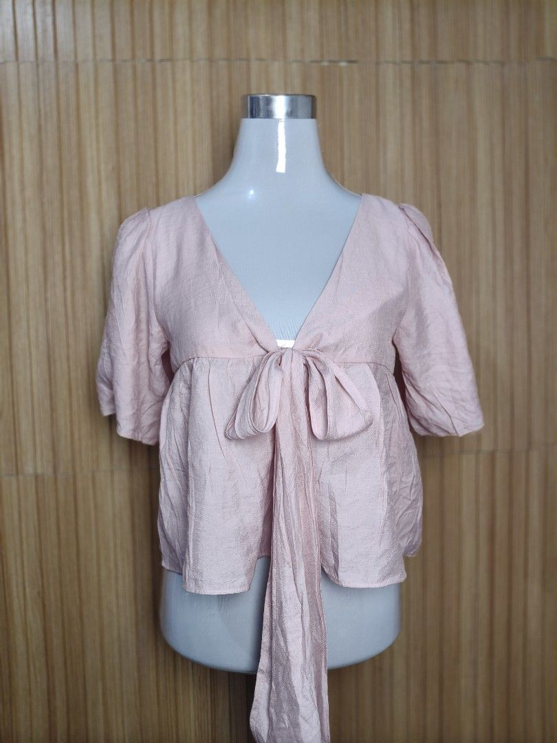 Kashieca Pink Front Tie Blouse Medium (Category: Blouses) located in Taguig. Submitted by ashie_clothing (Listing ID 1470367266, Image 1). Description: - Brand: Kashieca - Size: Medium - Color: Pink with a slight textured sheen - Style: V-neck, short sleeves, front tie closure - Condition: Brand new with original tag attached - Versatility: Great for casual wear or dressing up.
