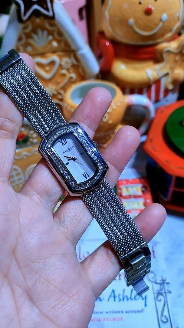 Kenneth Cole New York Crystal Rectangle Wristwatch Silver Mesh Strap (Category: Women's Watches) located in Baliuag. Submitted by marieannfernando23 (Listing ID 1470368402, Image 1). Description: - Brand: Kenneth Cole - Style: Silver-tone rectangular face watch with minimalist dial - Accents: Sparkling crystals on the bezel, Roman numerals at 12 and 6 o'clock - Strap: Unique woven mesh metal bracelet - Movement: Reliable quartz movement - Versati