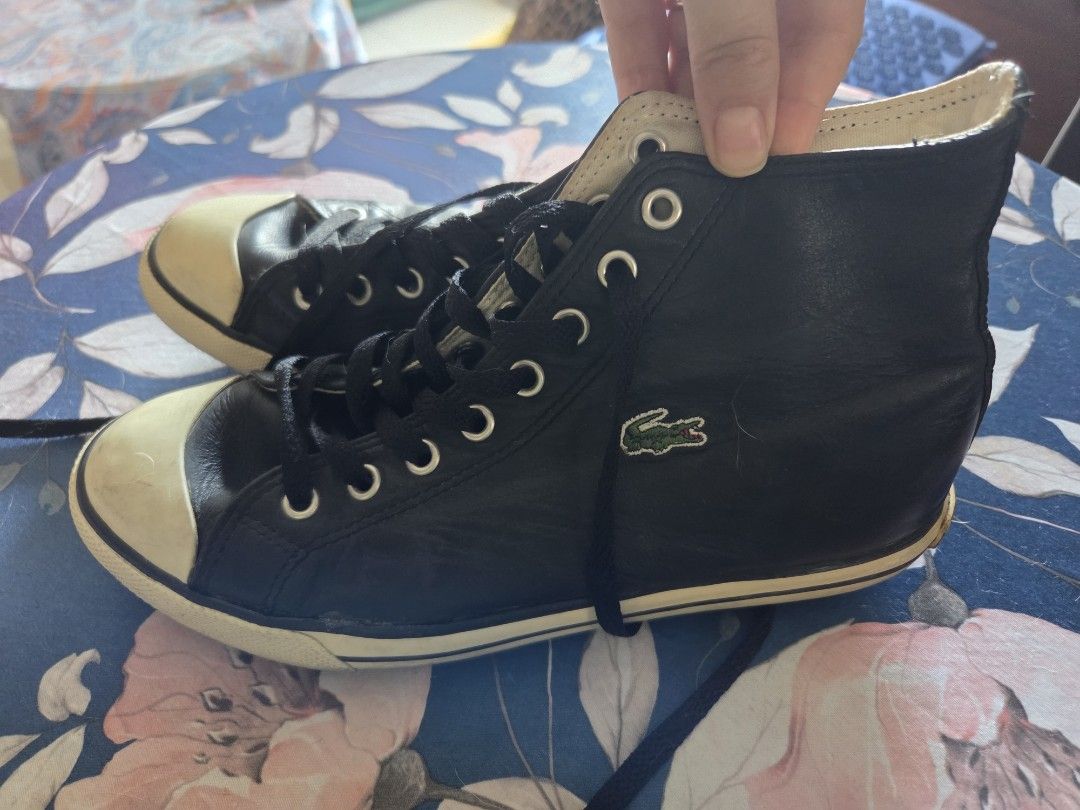 Lacoste Black High-Top Leather Sneakers (Category: Sneakers) located in Pasig City. Submitted by tatashki (Listing ID 1470390142, Image 3). Description: - Brand: Lacoste - Style: Black leather high-top sneakers - Details: White rubber toe caps and midsoles, black laces, embroidered side crocodile logo, and LACOSTE heel branding - Condition: Pre-owned with scuffing/discoloration on the toe caps and minor glue separation along the side sole (please