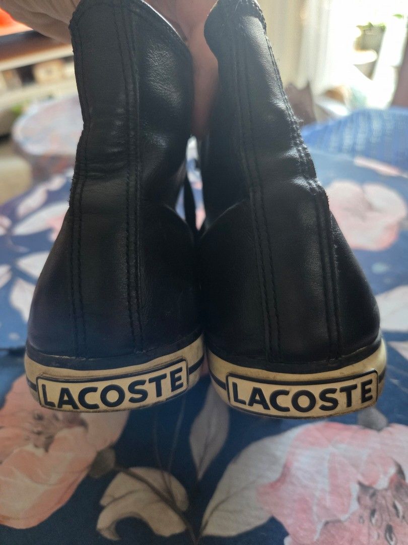 Lacoste Black High-Top Leather Sneakers (Category: Sneakers) located in Pasig City. Submitted by tatashki (Listing ID 1470390142, Image 2). Description: - Brand: Lacoste - Style: Black leather high-top sneakers - Details: White rubber toe caps and midsoles, black laces, embroidered side crocodile logo, and LACOSTE heel branding - Condition: Pre-owned with scuffing/discoloration on the toe caps and minor glue separation along the side sole (please