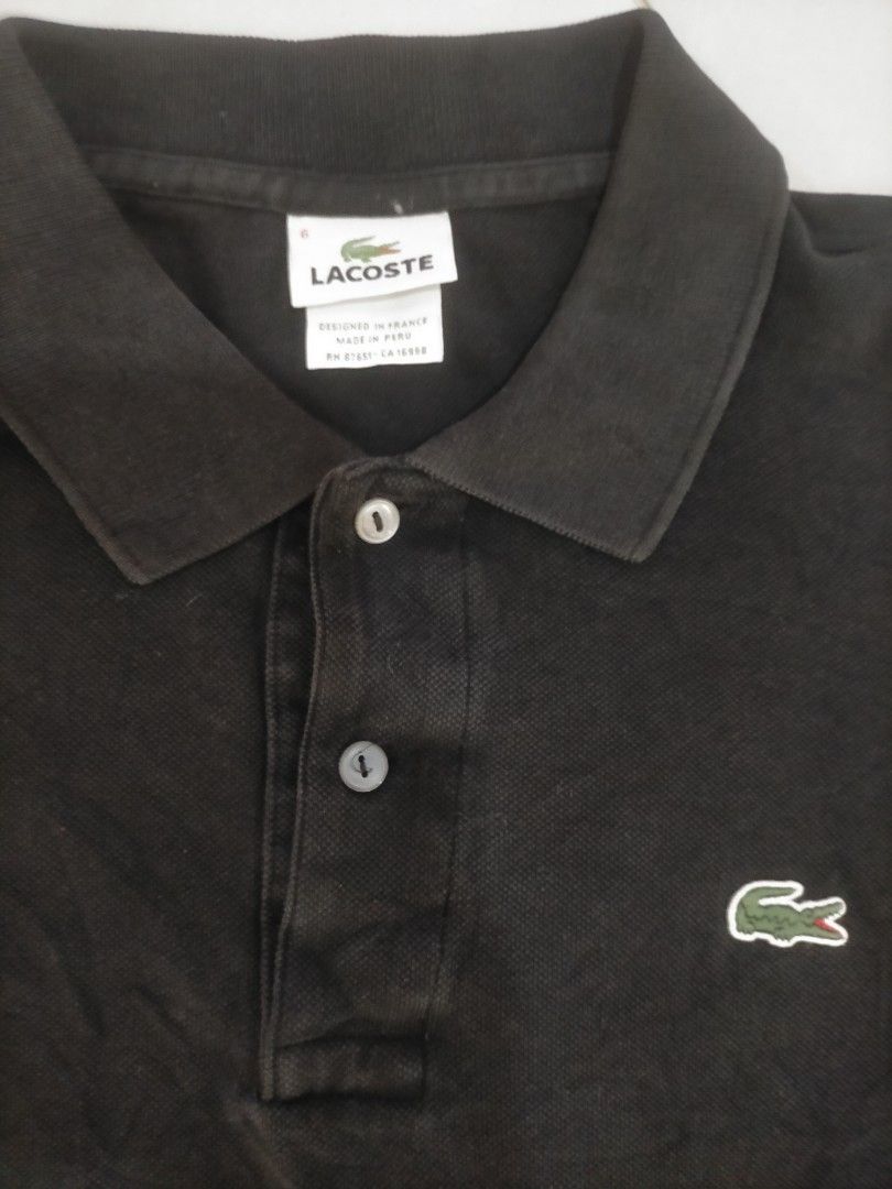 Lacoste Black Polo Shirt Size 6 (Category: Tshirts & Polo Shirts ) located in Manila. Submitted by zenphoenix_b0c89e (Listing ID 1470443482, Image 2). Description: - Brand: Lacoste - Color: Black - Size: 6 (Standard fit) - Material: 100% Cotton (Style: 5191L, Made in Peru) - Design: Short sleeves, button placket - Branding: Iconic green embroidered crocodile logo on the chest - Condition: Breathable and comfortable fabric.