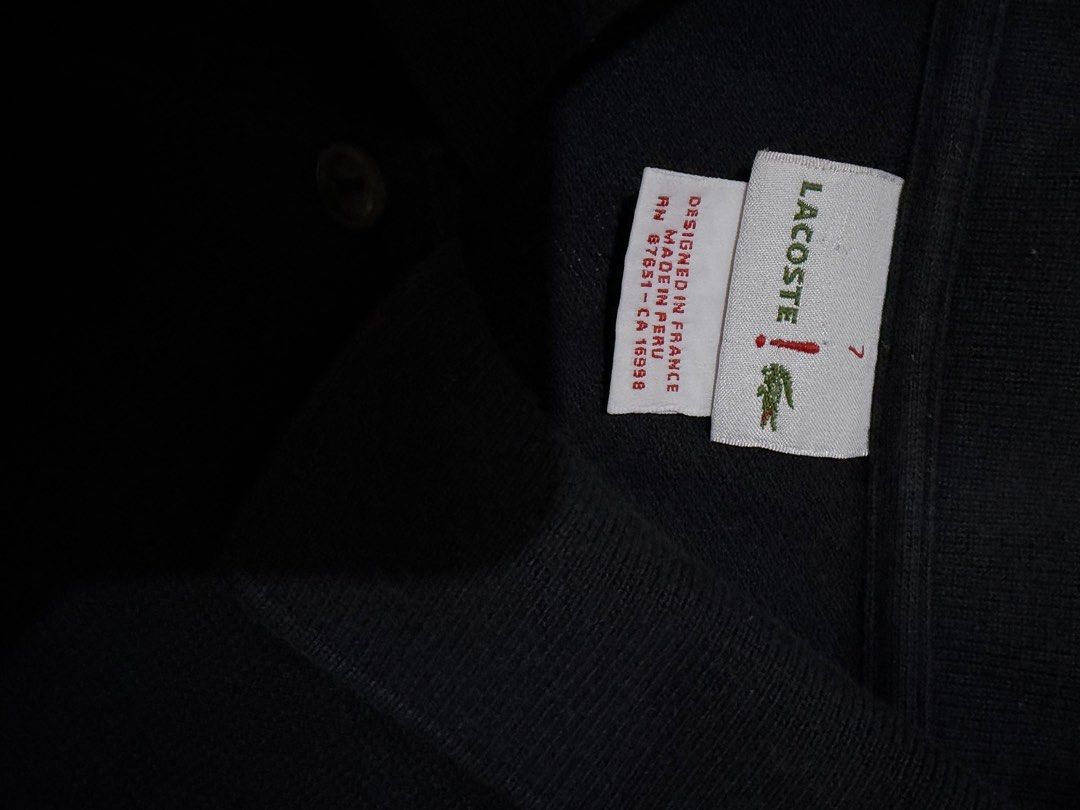 Lacoste Black Polo Shirt Size 7 (Category: Tshirts & Polo Shirts ) located in Taguig. Submitted by otw.up (Listing ID 1470504937, Image 3). Description: - Brand: Lacoste - Color: Classic Black - Details: Iconic green crocodile logo, two-button placket, and classic collar - Authenticity: Includes Devanlay care tag - Origin: Made in Peru - Condition: Great staple piece for everyday casual wear -Dimes 22x28.