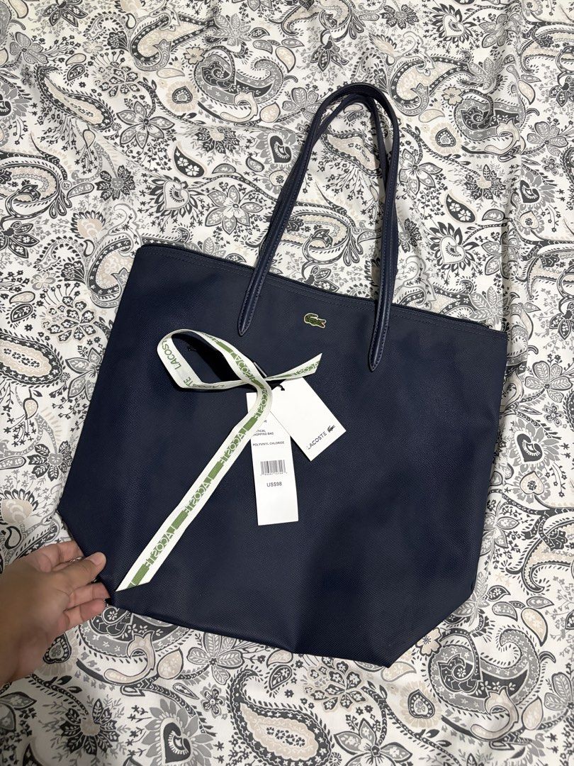 Lacoste L.12.12 Concept Vertical Zip Tote Bag (Category: Tote Bags) located in Mapandan. Submitted by thrifty.nifty.tara (Listing ID 1470454507, Image 2). Description: Used once Authentic Purchased in Amazon US (Lacoste store) Penombre blue One interior zip net pocket with hook Lacoste branded zipper slider Embroidered Tone-on-Tone Crocodile branding Outside: Pvc (100%).