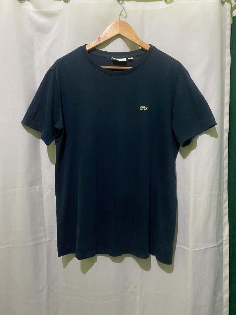 Lacoste navy blue crew neck t-shirt (Category: Shirts) located in Quezon City. Submitted by elihur.tuazon (Listing ID 1469683146, Image 3). Description: - Brand: Lacoste - Color: Navy blue - Design: Classic crew neck with embroidered crocodile logo on chest - Fit: Regular fit, short sleeves - Material: Soft and comfortable cotton - Condition: Excellent, neckline tag intact - Style: Versatile, easy to pair with jeans or shorts.