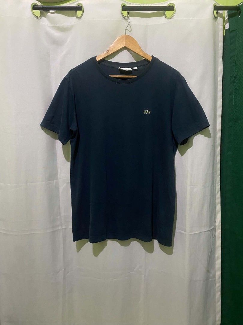 Lacoste navy blue crew neck t-shirt (Category: Shirts) located in Quezon City. Submitted by elihur.tuazon (Listing ID 1469683146, Image 2). Description: - Brand: Lacoste - Color: Navy blue - Design: Classic crew neck with embroidered crocodile logo on chest - Fit: Regular fit, short sleeves - Material: Soft and comfortable cotton - Condition: Excellent, neckline tag intact - Style: Versatile, easy to pair with jeans or shorts.