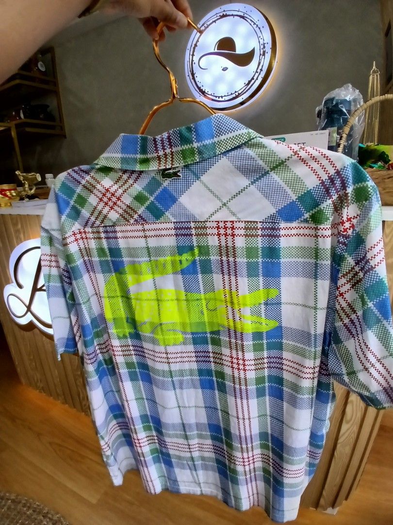 Lacoste Plaid Button-Up Long Sleeve Shirt (Category: Coats, Jackets and Outerwear) located in Manila. Submitted by charlene_selda29 (Listing ID 1470385374, Image 2). Description: - Brand: Lacoste - Style: Long sleeve button-up shirt in a multi-color plaid pattern (white, blue, green, red) - Details: Classic collar, front button closure, and chest pocket - Logos: Signature embroidered crocodile on the chest and a statement neon yellow printed croc